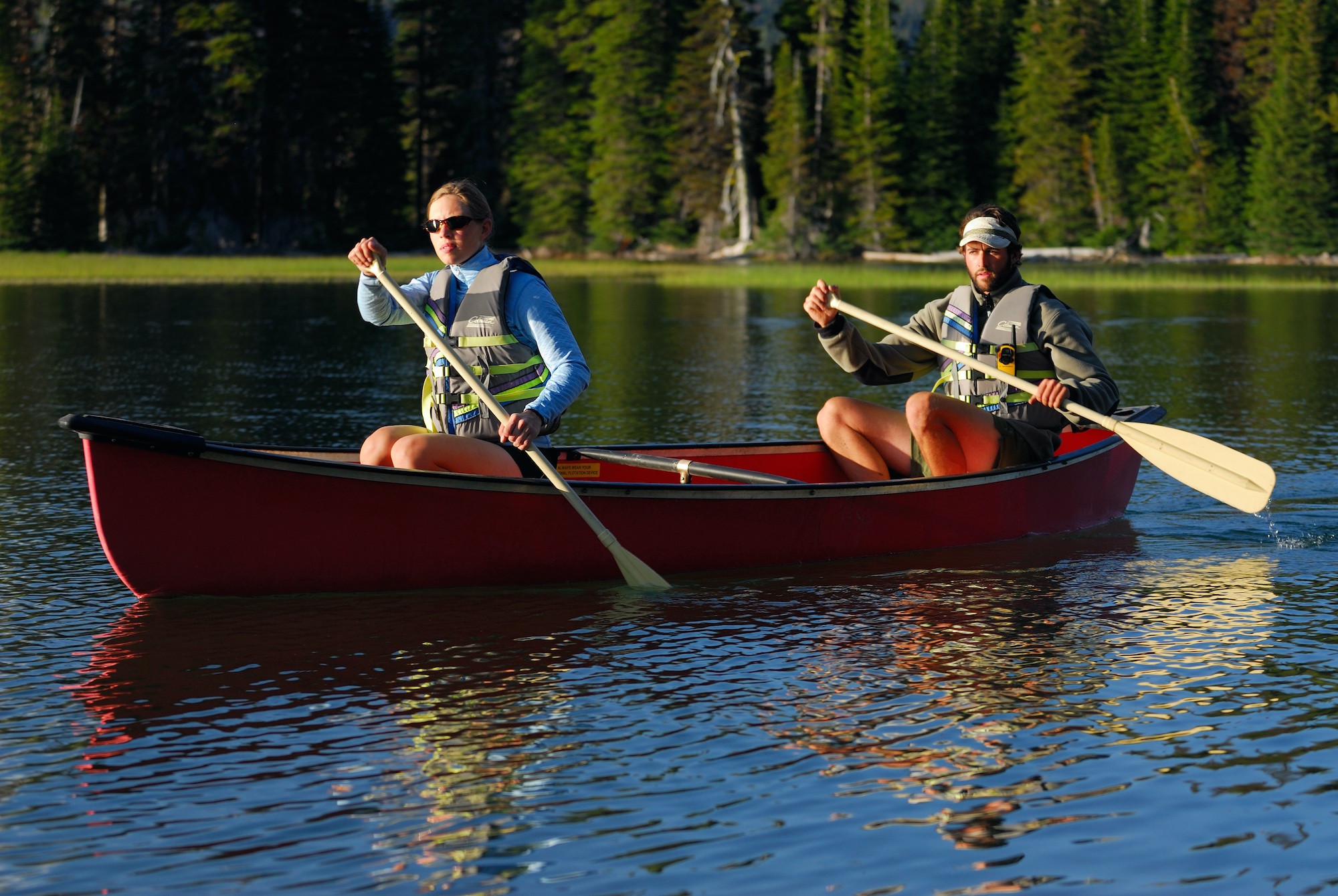 Man and woman paddling in a red canoe on Sparks Lake
