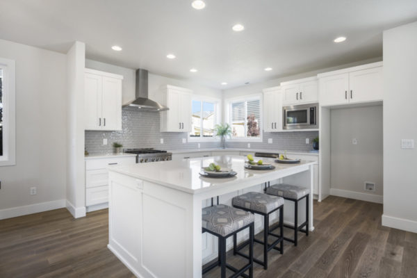 white kitchen with grey backsplash, white island